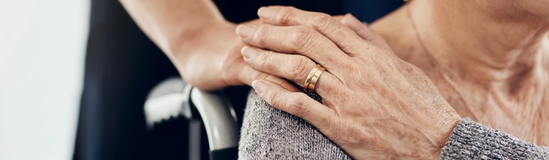 Osoba trzymająca dłoń na ramieniu starszej osoby